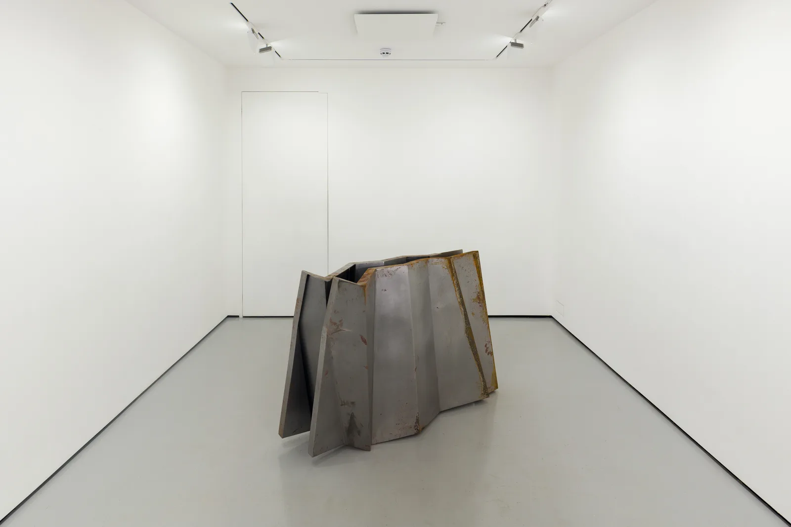 a steel sculpture by Hannah Perry with 2 walls in a ziggurat shape slightly apart from each other