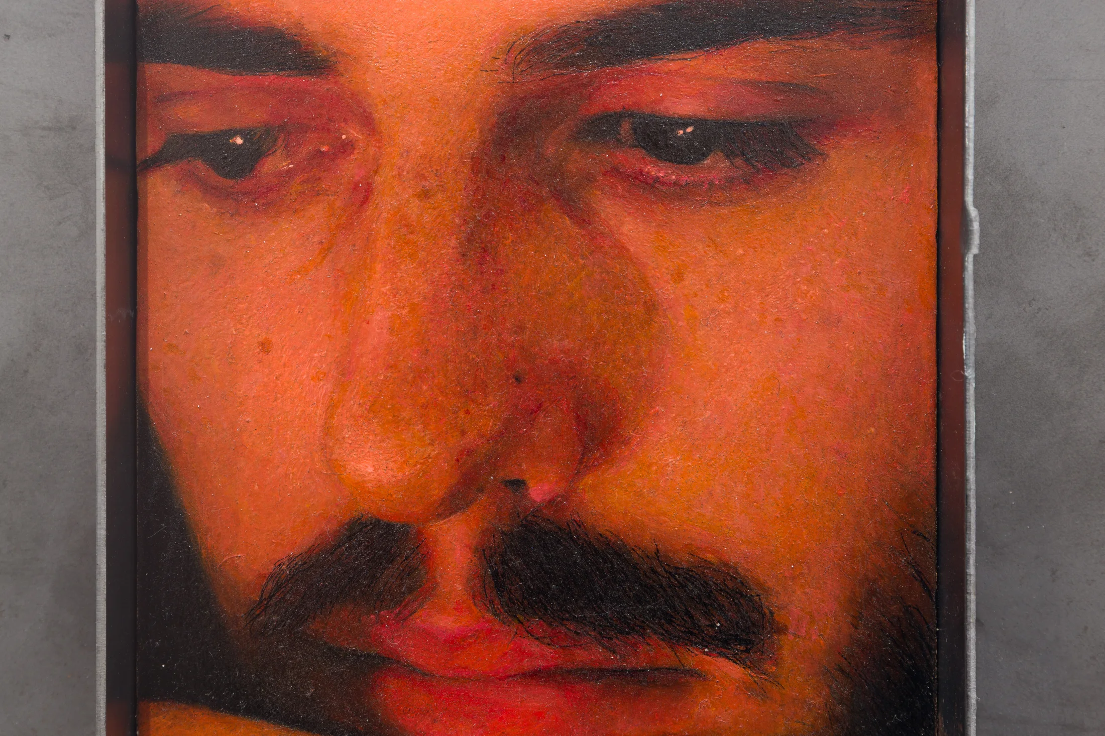 A painting by Ki Yoong of the closeup of a man's face in a metal frame