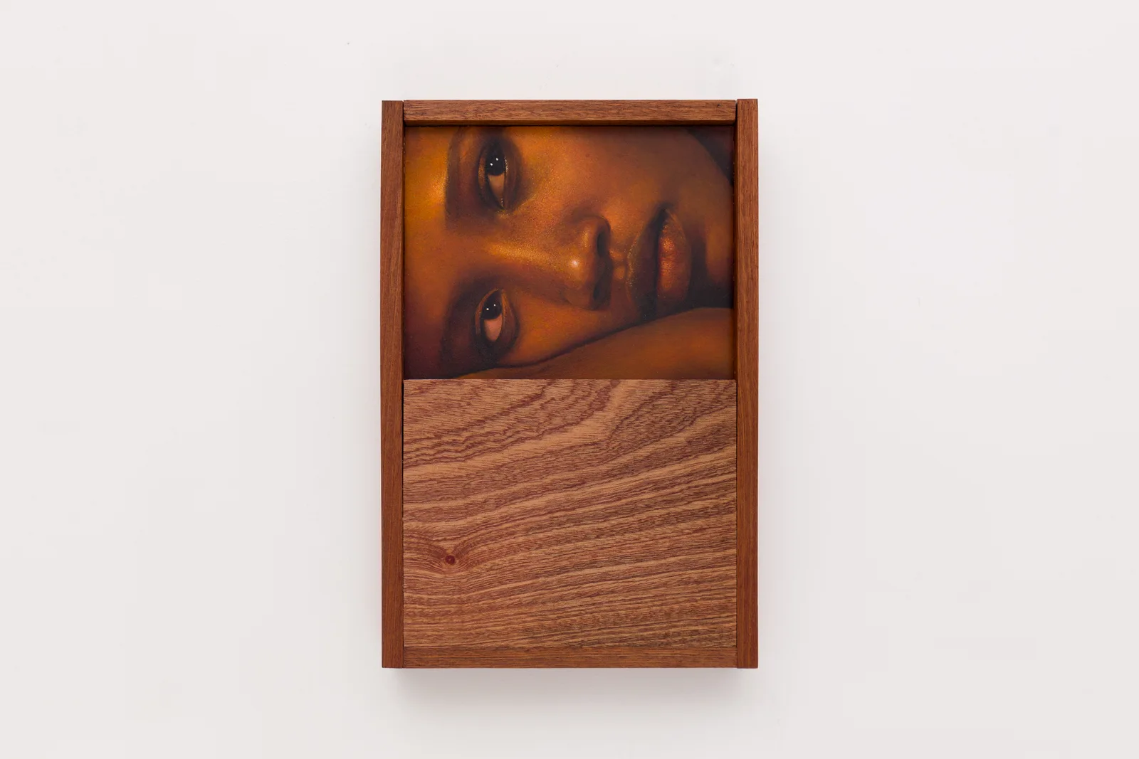A close-cropped oil on board portrait by Ki Yoong of a young Black woman lying on her side, incorporating a hardwood frame and lower panel