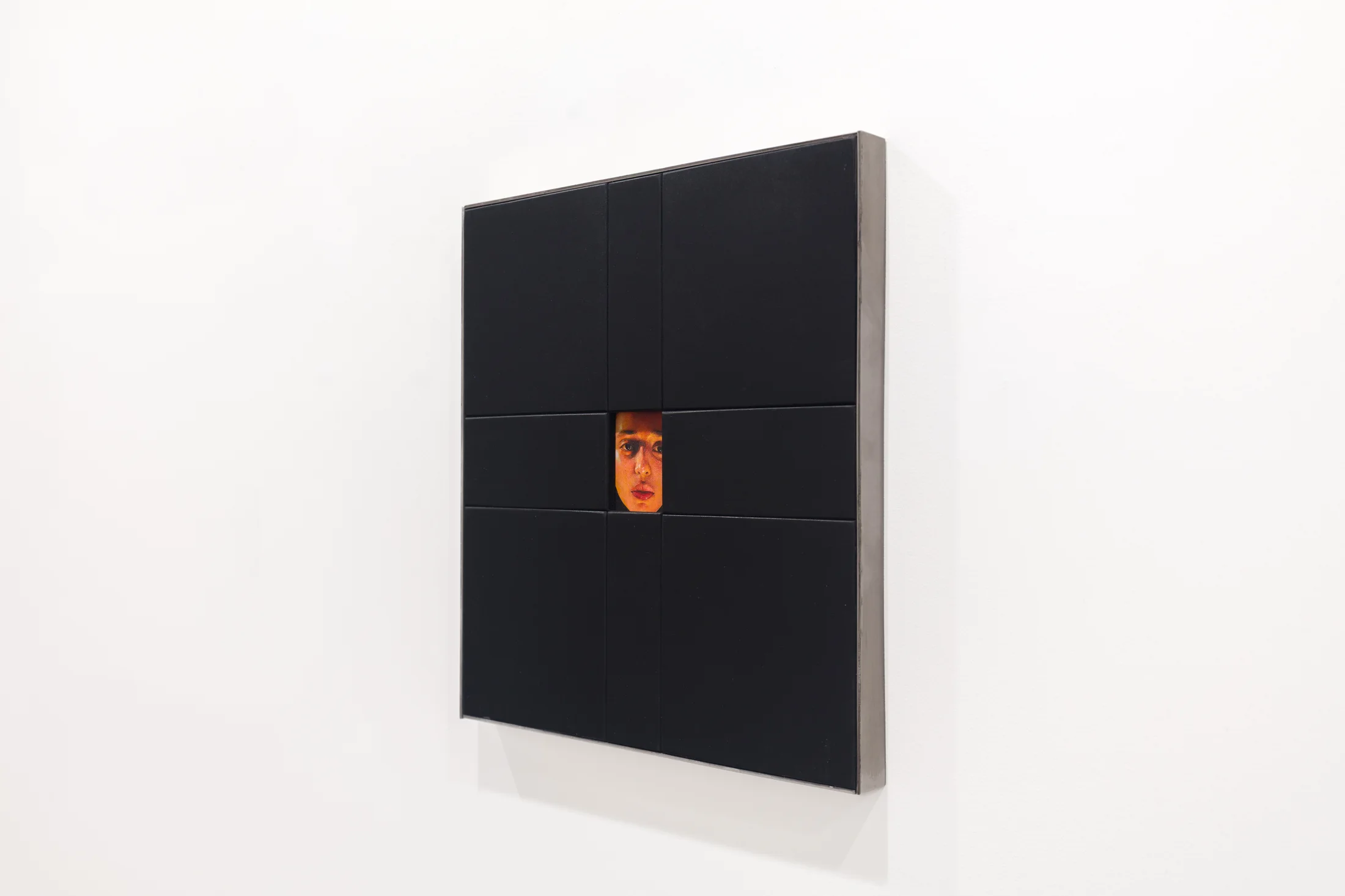 A painting by Ki Yoong of a woman's face framed within a large black wooden frame
