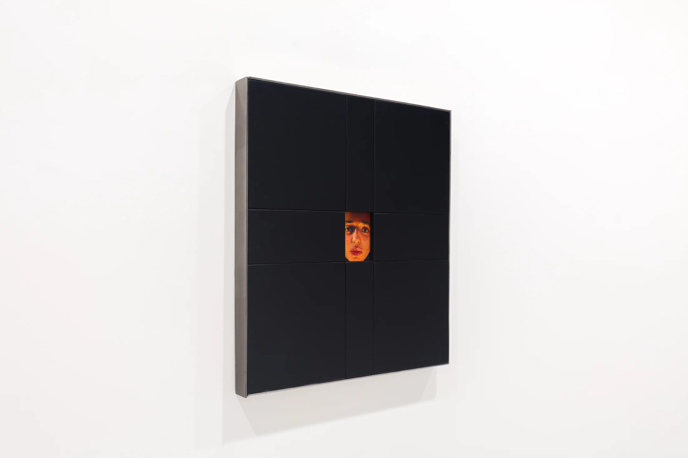 A painting by Ki Yoong of a woman's face framed within a large black wooden frame