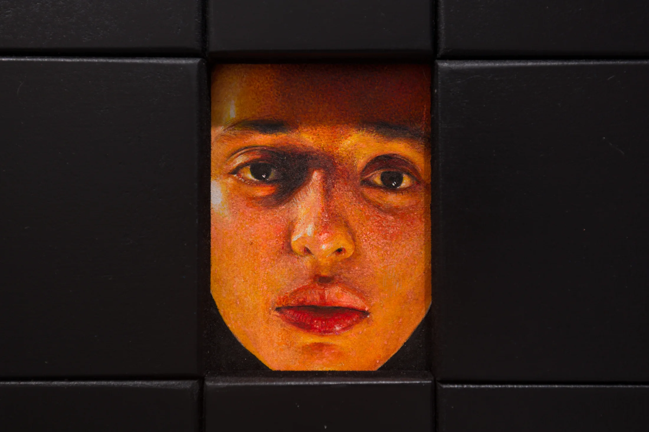 A painting by Ki Yoong of a woman's face framed within a large black wooden frame