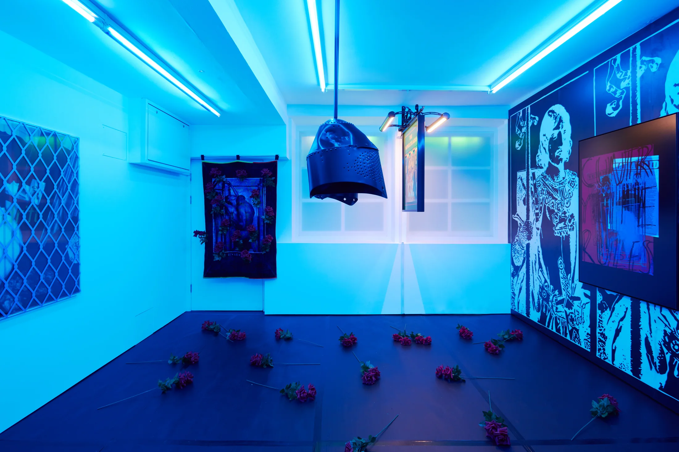 Installation images of Simeon Barclay's exhibition at Workplace in London, artworks, sculpture and video are cast in filtered blue light of a night club