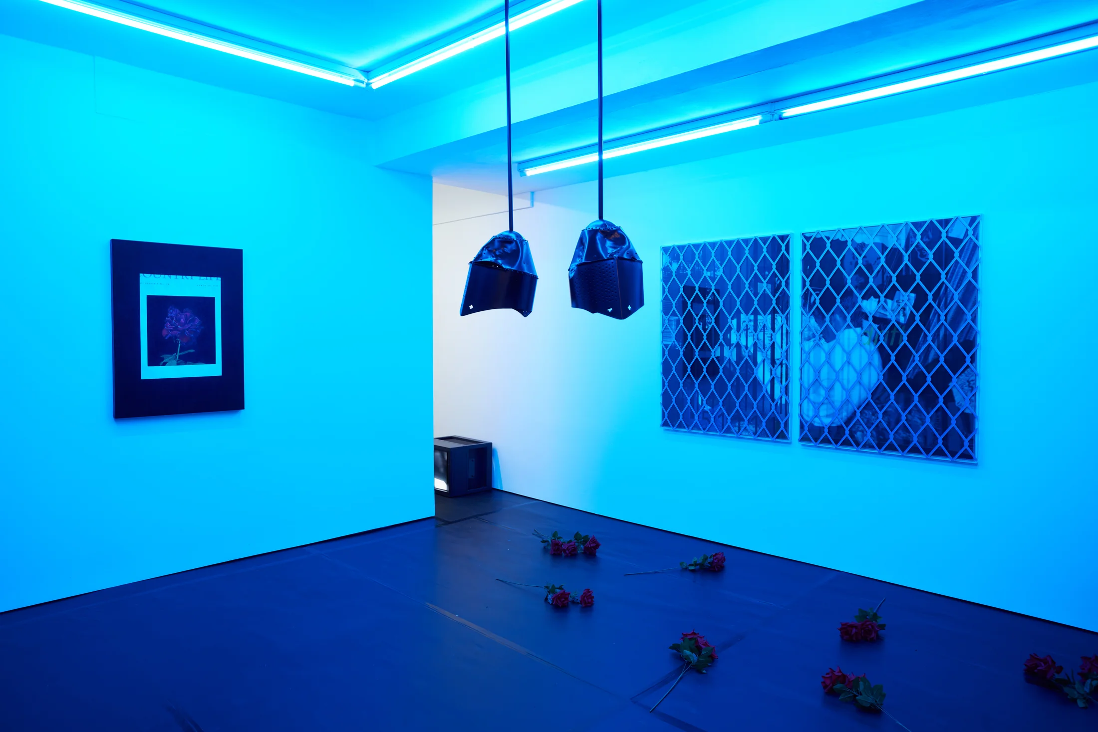 Installation images of Simeon Barclay's exhibition at Workplace in London, artworks, sculpture and video are cast in filtered blue light of a night club