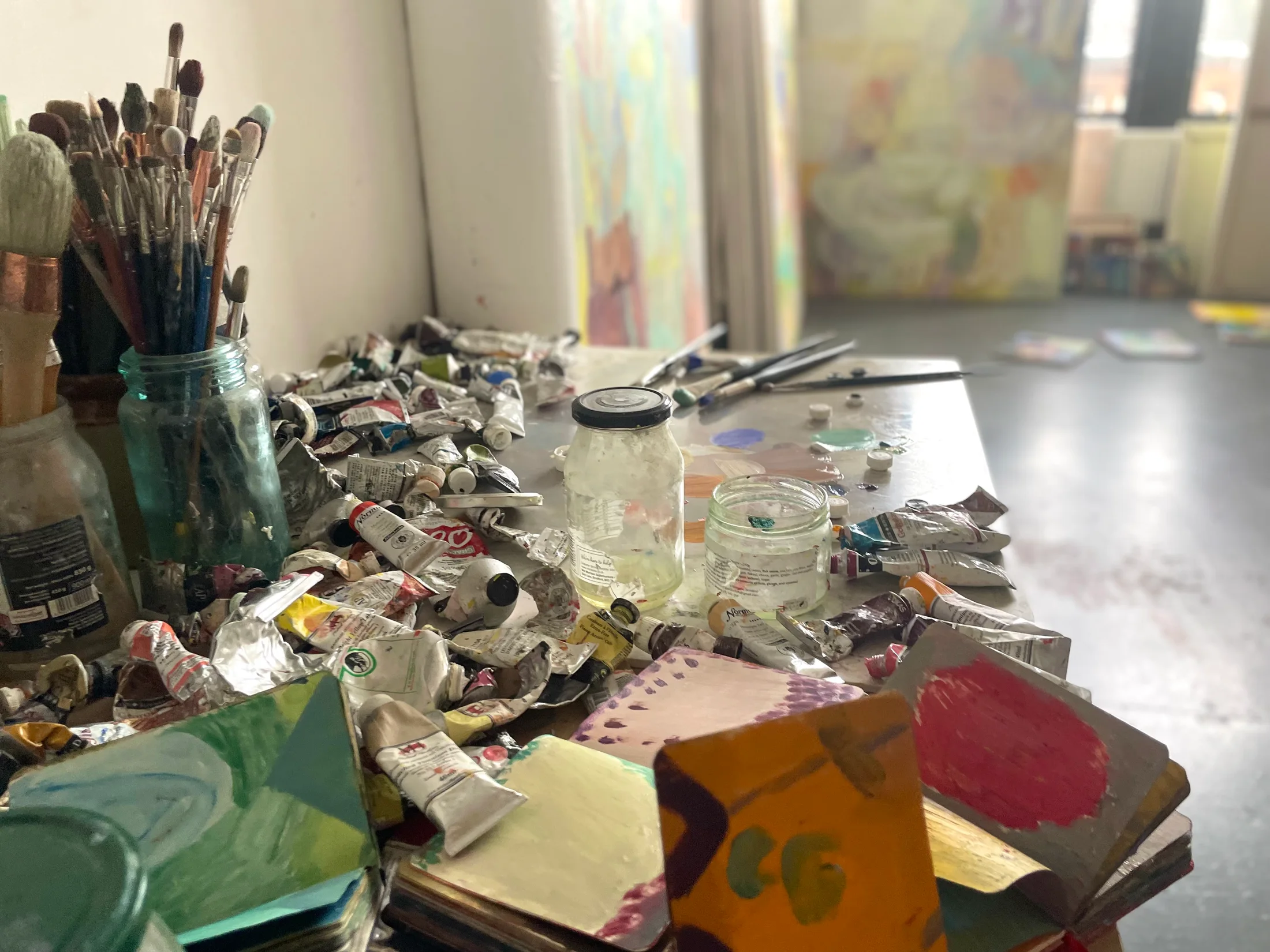 A table with paint and sketchbooks in Amy Winstanley's studio