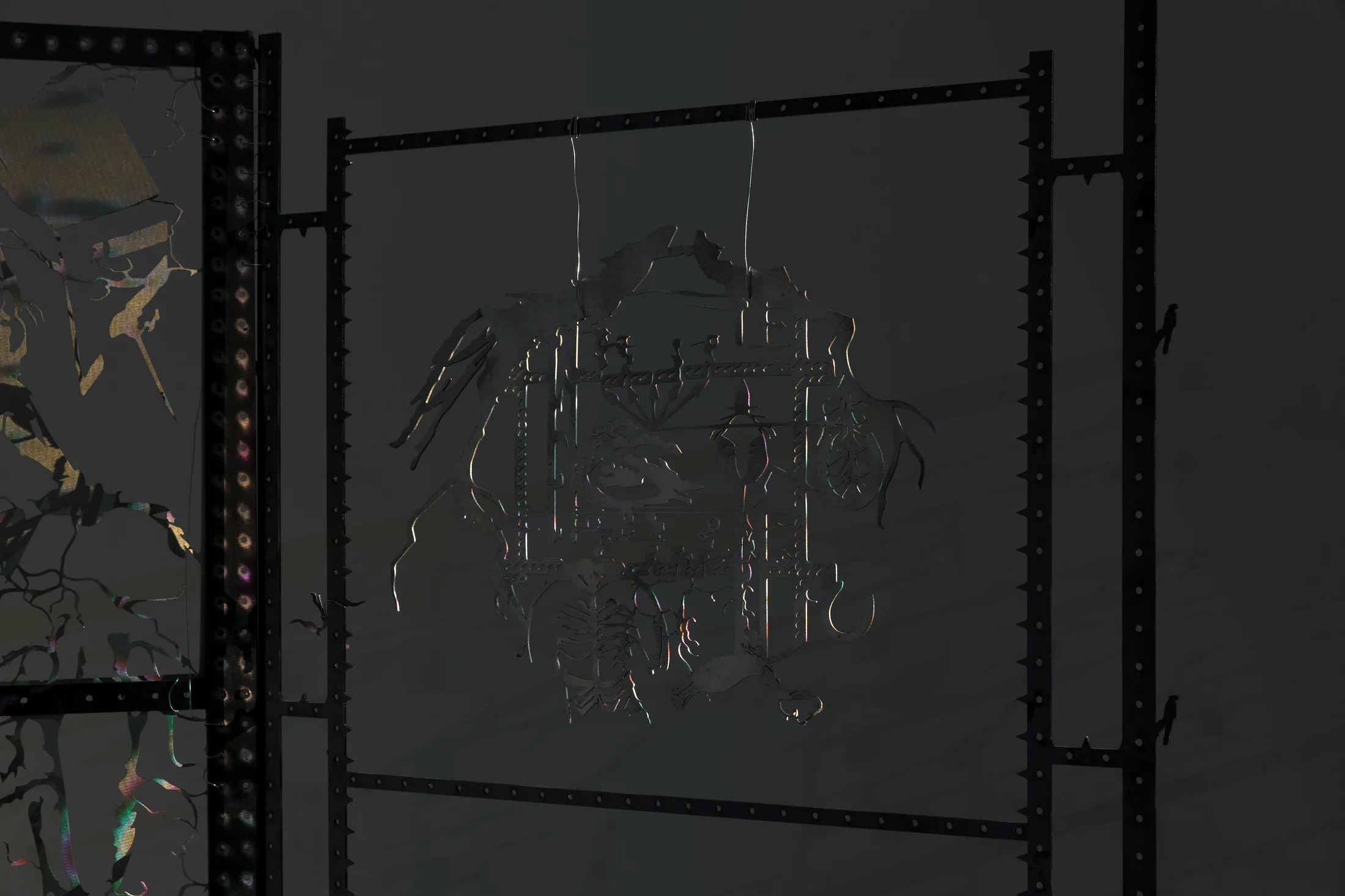An installation by Hazel Brill including a water tanks filled with a dark liquid laser cut steel dividers, mouth-blown glass objects, projections and lights