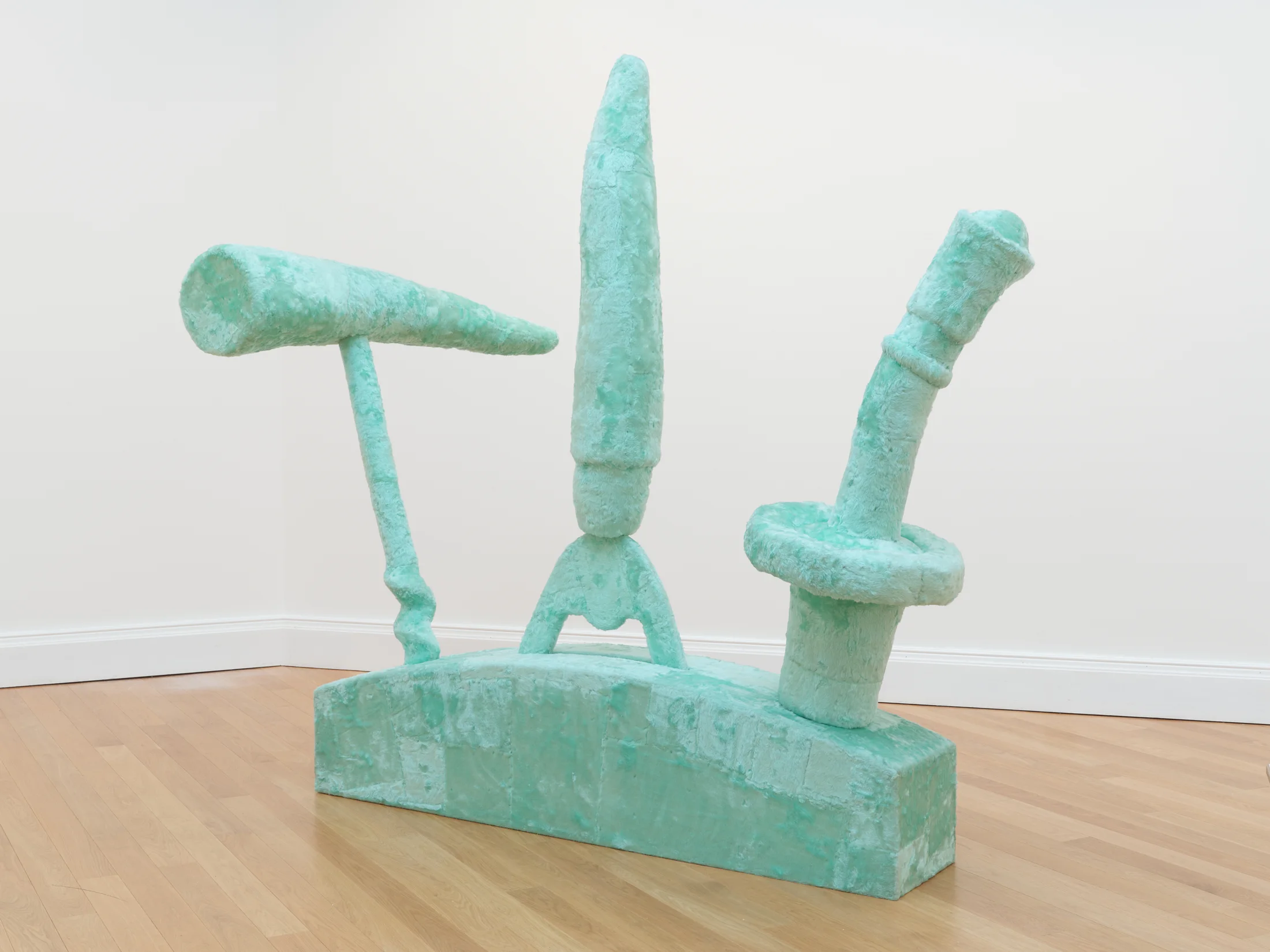 A large turquoise synthetic fur sculpture by Eric Bainbridge featuring an oversized bartender set