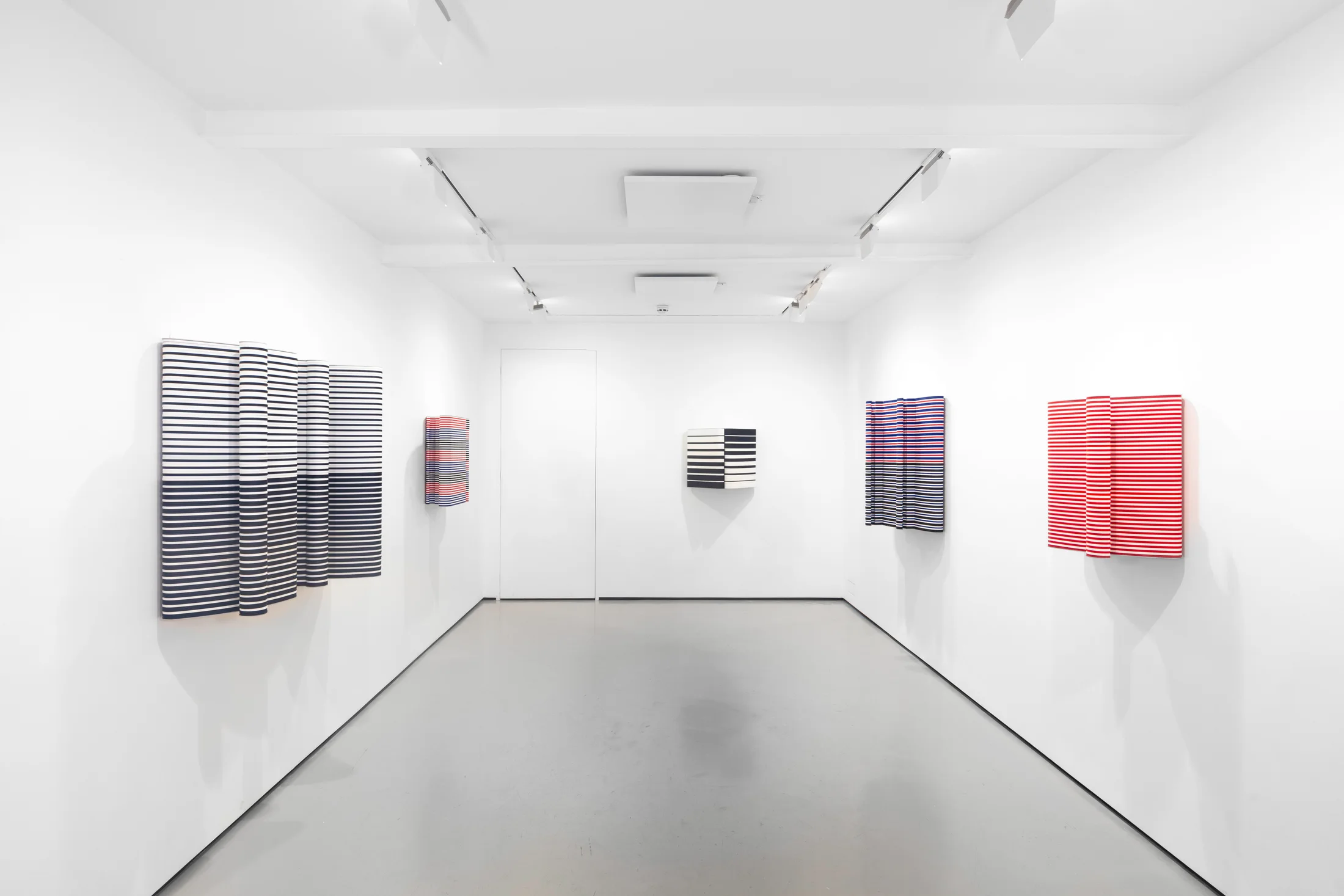 An installation view of Jacob Dahlgren's wall based sculptures made from coloured coat hangers 
