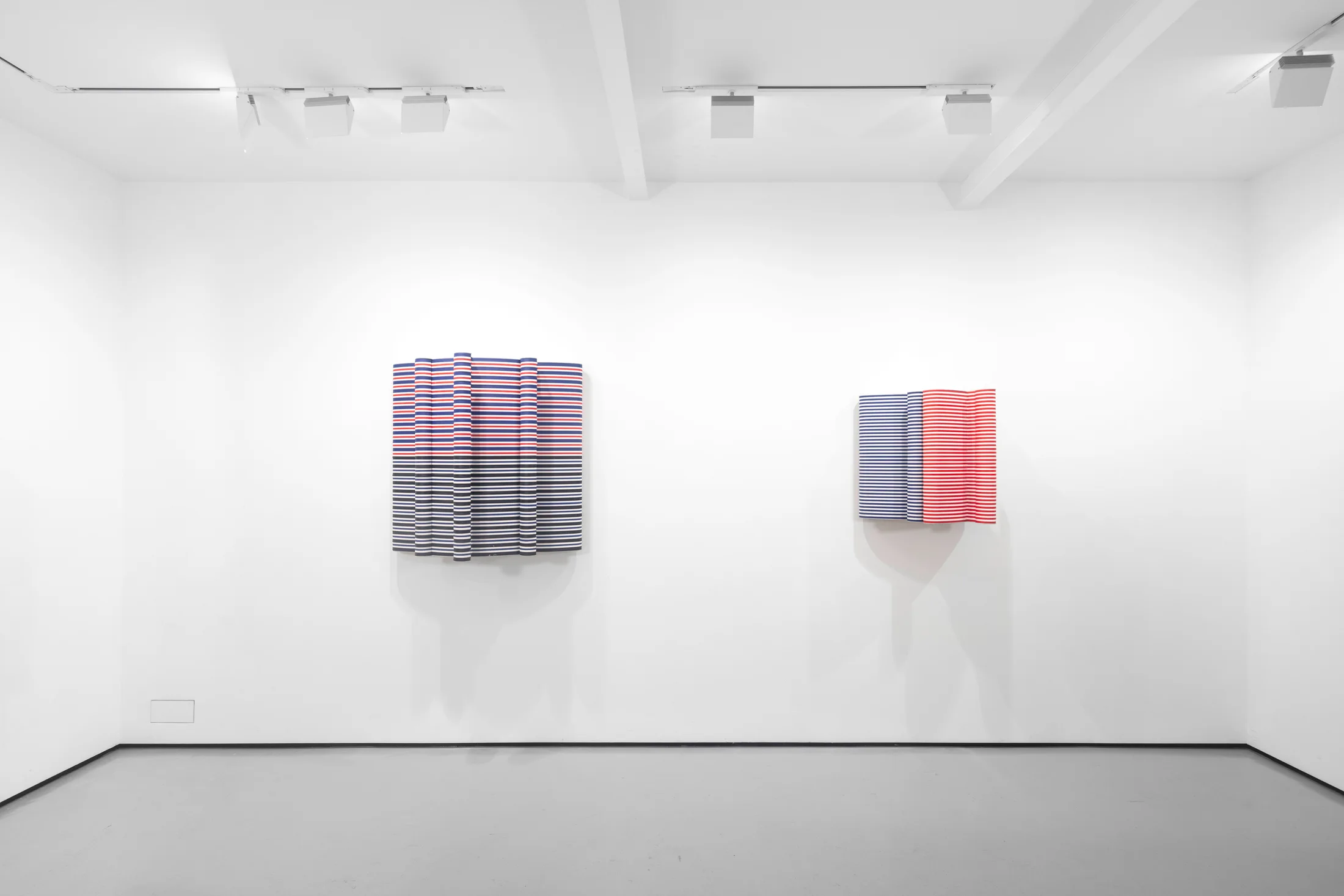 An installation view of Jacob Dahlgren's wall based sculptures made from coloured coat hangers 